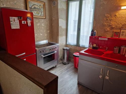 a kitchen with a red refrigerator and a sink at Welcome to SWEET HOME in Bélâbre