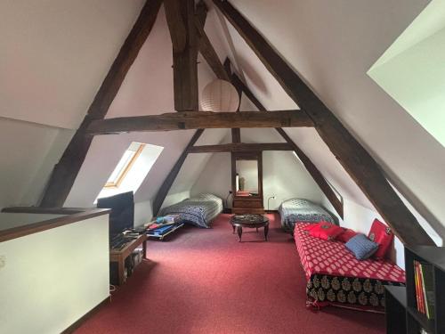 a attic room with two couches and a room with beams at Welcome to SWEET HOME in Bélâbre