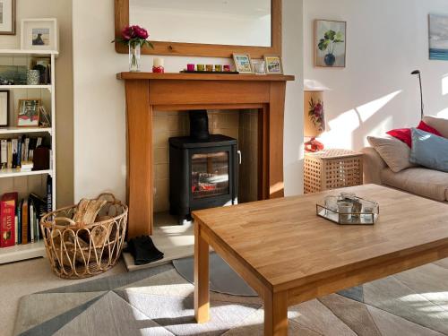 a living room with a fireplace and a table at Bents Retreat in Montrose