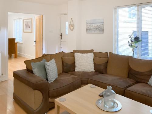 a living room with a brown couch and a coffee table at The Old Forge in Alnwick