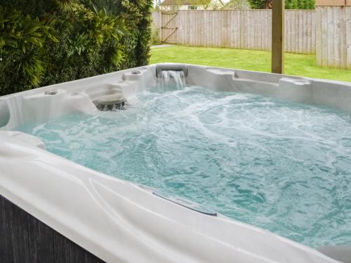 a hot tub with a waterfall in a backyard at Lyndhurst in Longhorsley