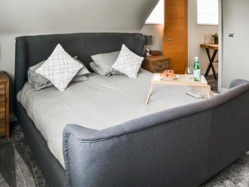 a gray couch with pillows and a table on it at Lyndhurst in Longhorsley