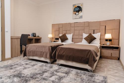 タシュケントにあるArt Dream Hotelのベッドルーム1室(ベッド2台、大型ヘッドボード付)