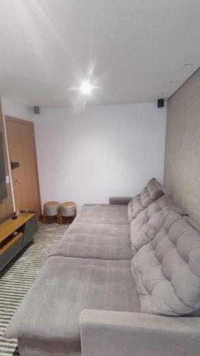 a large bed in a room with a couch at Belíssimo Apartamento Aeroporto in Várzea Grande