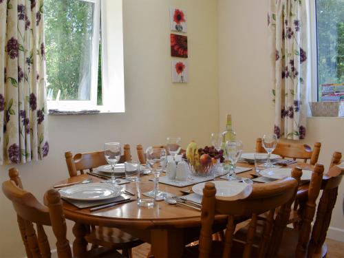 a dining room table with chairs and glasses on it at Green Valley Retreat in Holsworthy