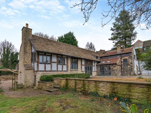 an old stone house with a fence in front of it at Waterside House in Knaresborough