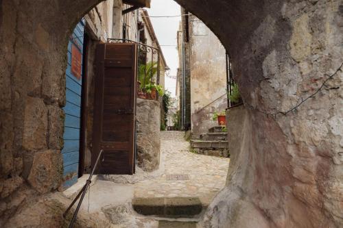 an alley with an open door in a stone building at officina alchemica in Calcata