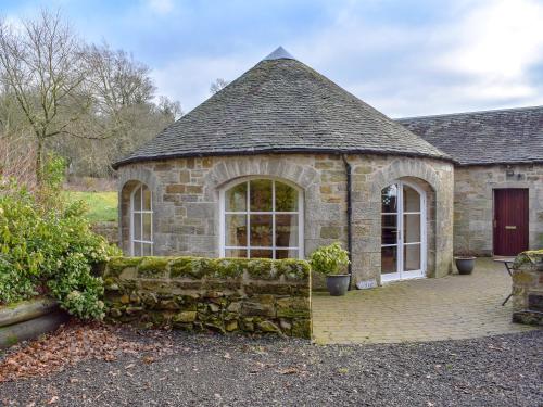 an old stone house with a large window at Horsemill - Uk10794 in Ballingry