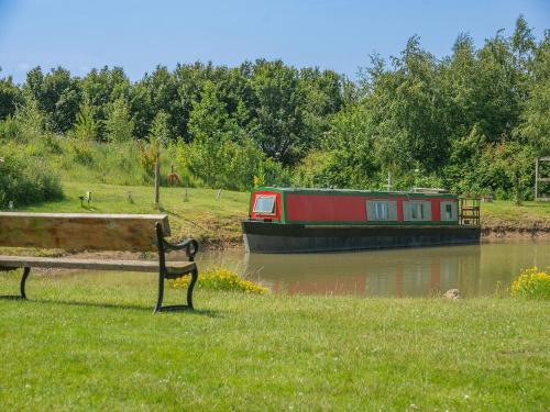 a bench sitting in the grass next to a boat at Primrose - W43303 in Goxhill