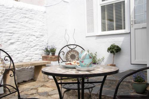 a table with chairs and a bowl on a patio at Summers Beach View in Saint Mawes