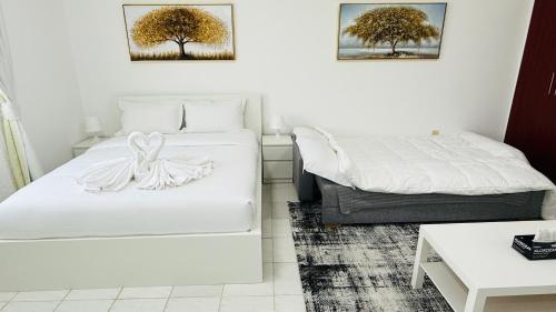 a hotel room with two beds and a table at Z01 Furnished Studio Garden view International city in Dubai