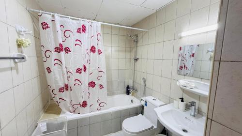 a bathroom with a toilet and a shower curtain at Z01 Furnished Studio Garden view International city in Dubai