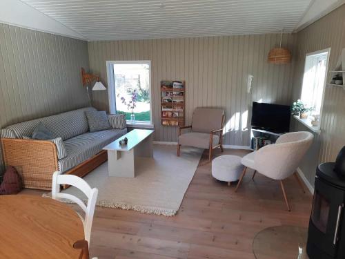 a living room with a couch and a table at Cozy 6 person holiday home in Juelsminde - 5 minutes walk to the beach in Sønderby