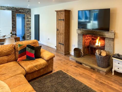 a living room with a couch and a fireplace at Home Farm - The Dairy -Uk34626 in Dunragit