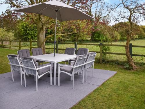 a white table and chairs with an umbrella at Swallowdale in Flordon
