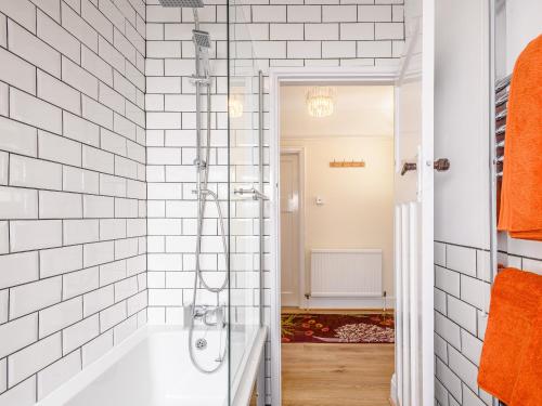 a bathroom with a shower with white tiled walls at Grayson Avenues in Pakefield