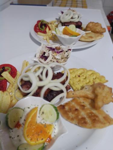 a white table with plates of food on it at Glamping Ohrid lake view stone in Polje