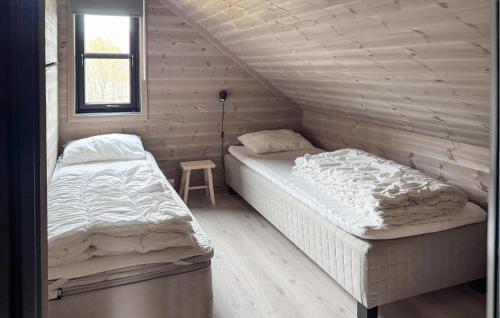 a bedroom with two beds in a wooden cabin at Lovely Home In Vikeså With Kitchen in Vikeså