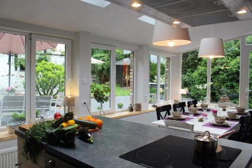 a kitchen with a table with fruits and vegetables on a counter at Le Néblon insolite in Ouffet