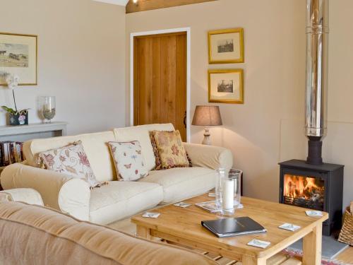 a living room with a couch and a wood stove at The Peacock Barn in Burwash