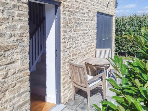 a patio with a table and a chair and a door at The Fold in Appleton