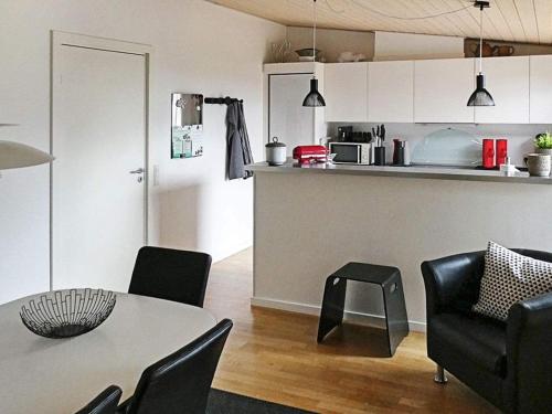 a living room with a table and chairs and a kitchen at Exclusive Retreat with Spa - By Traum Ferienwohnungen in Rømø Kirkeby
