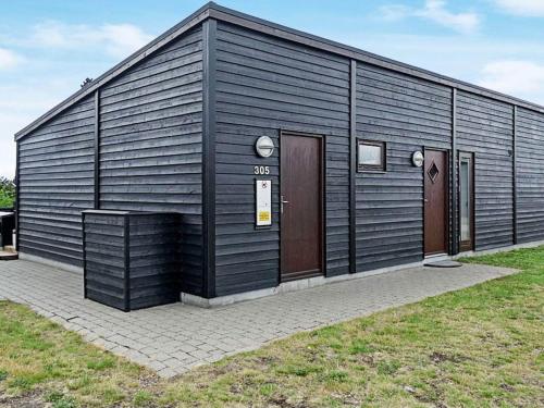 a black building with two doors on the side of it at Exclusive Retreat with Spa - By Traum Ferienwohnungen in Rømø Kirkeby