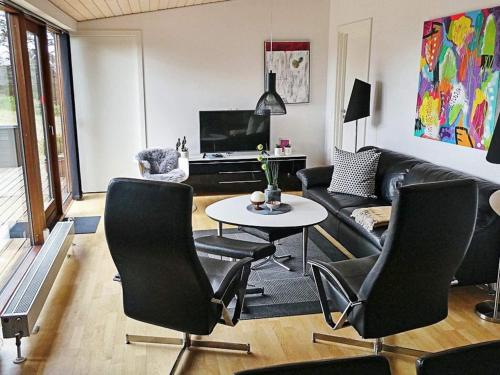 a living room with a couch and a table and chairs at Exclusive Retreat with Spa - By Traum Ferienwohnungen in Rømø Kirkeby