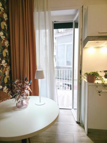 a table with a lamp on it in a room with a window at Romi Suite in Rome