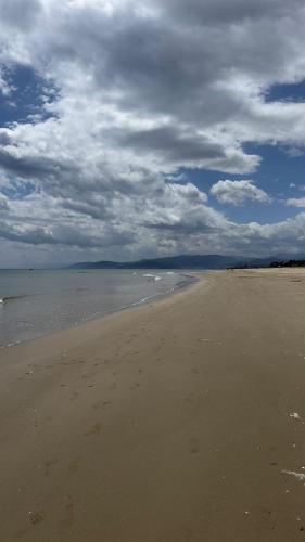 an empty beach with a cloudy sky and the ocean at Appartement lilac's garden in Tetouan