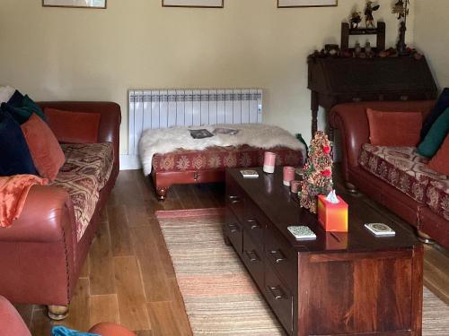 un salon avec un canapé et une table basse dans l'établissement Wisteria Cottage, à Alnham