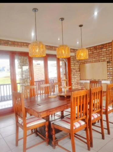 a dining room with a wooden table and chairs at C - Views in Jongensfontein