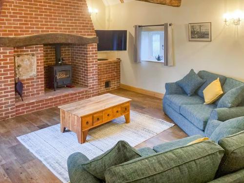 a living room with two couches and a fireplace at The Dairy - Uk48866 in Aylsham