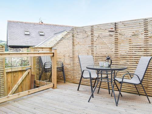 a patio with a table and chairs on a balcony at Holmfield in Buxton