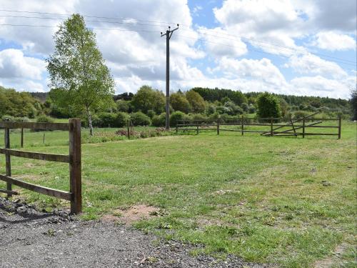 a fence in a field with grass and trees at Sherwood Forest Lodge 2 in Clipstone