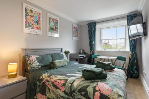 a bedroom with a bed and a desk and a window at River Inn Guesthouse in Dublin