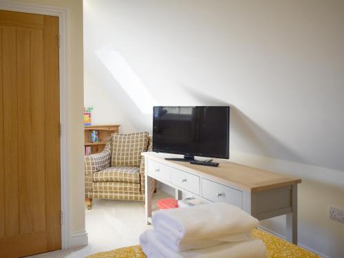 a living room with a television on a desk at Puxton Lodge in Fordwich