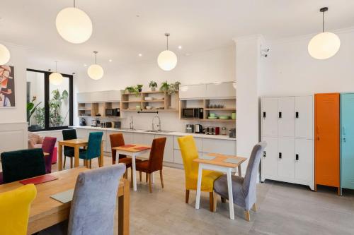 a kitchen and dining room with colorful chairs and tables at River Inn Guesthouse in Dublin