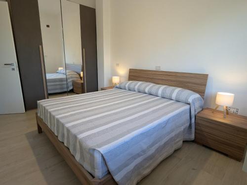 a bedroom with a large bed and a mirror at Riva di Davoli One Bedroom Apartment in Marina di Davoli
