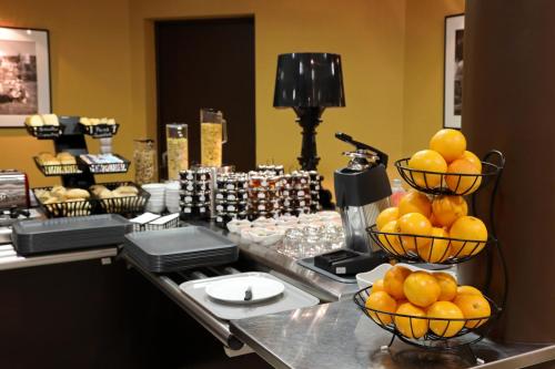a buffet with oranges in baskets on a counter at Logis Hotel des Cépages in Arbois
