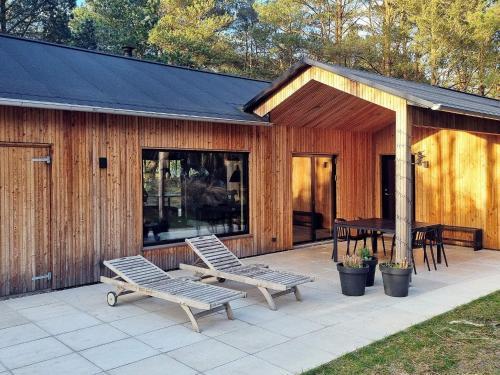 a patio with two benches and a table in front of a building at 8 person holiday home in Ålbæk in Ålbæk