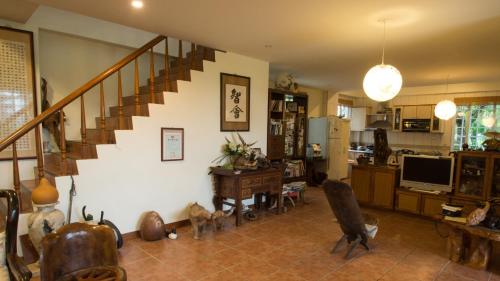 a living room with a staircase and a desk and a room at Wisdom Garden Home Stay in Yuli