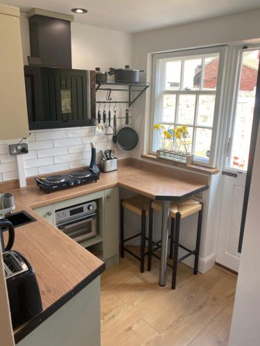 a kitchen with a wooden table and a counter top at Charming cozy cottage in Guisborough in Guisborough