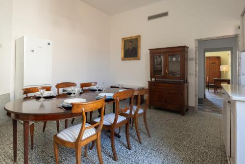 a dining room with a table and chairs and a kitchen at MATTEOTTI ROOMS in Sarzana
