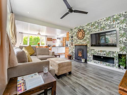 een woonkamer met een bank en een open haard bij By The Beach- Uk31201 in Downderry