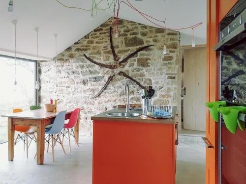 una cucina con un tavolo e un muro di pietra di Stone Cottage a Elgol