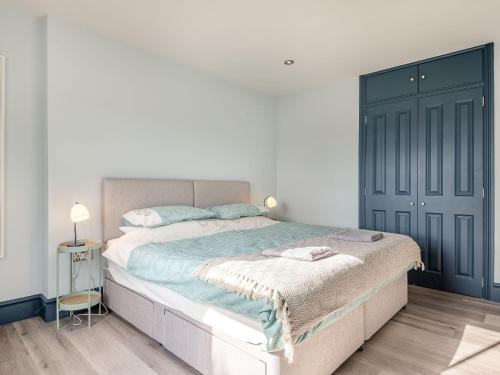 a bedroom with a large bed with a blue door at Gwrlodde in Talgarth