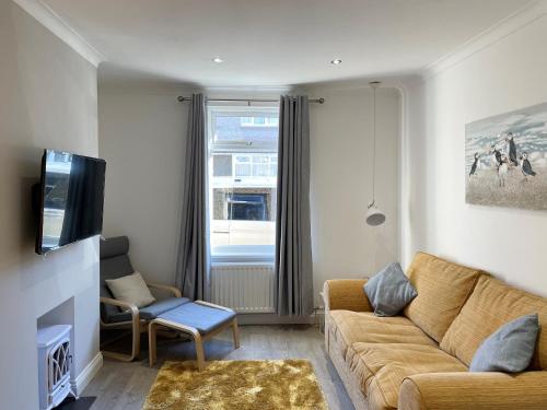 a living room with a couch and a tv at Harbour Walk in Amble