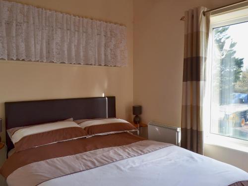 a bedroom with a bed and a large window at Flat F1 in Dawlish Warren