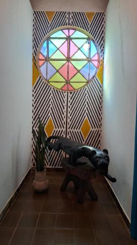 una camera con tavolo e finestra istoriata di Hospedagem Aldeia Multiétnica a Alto Paraíso de Goiás